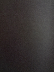 Close-up of a dark textured leather surface with small pebble grain.