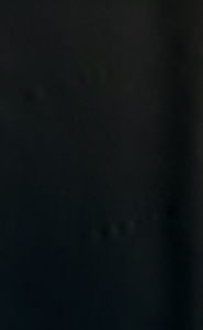 Close-up of a dark black textured surface resembling leather or vinyl.