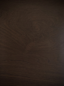 Dark brown wooden surface with visible grain and subtle texture (tabletop/wood panel).